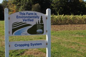 Sign on field reads "This farm is environmentally verified."