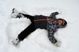 boy laying in snow
