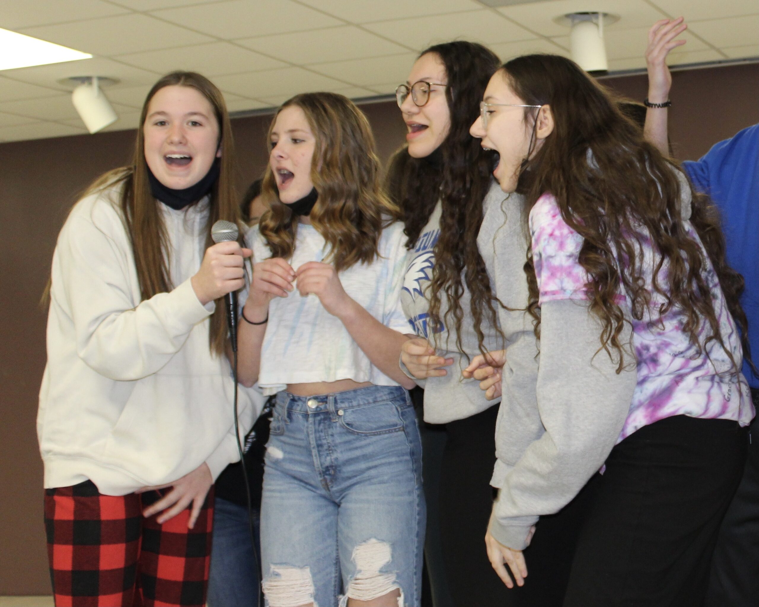 Girls singing into a microphone.