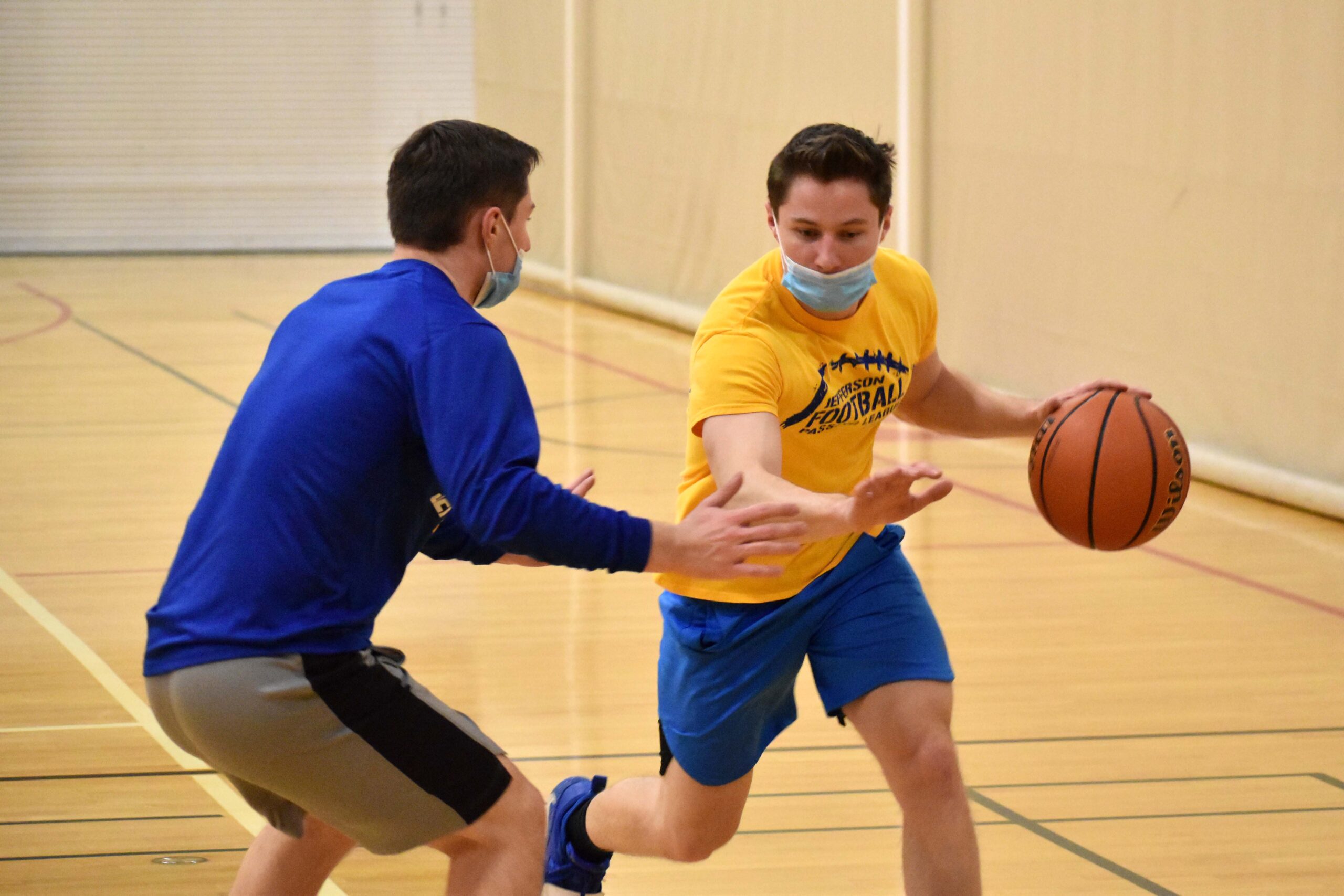guy dribbling basketball with someone guarding them